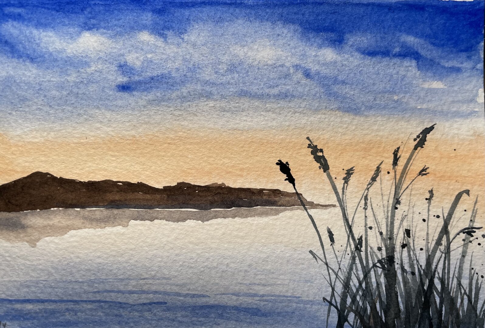 This watercolor painting depicts a tranquil lakeside scene at sunset, with a warm orange glow near the horizon, deep blue sky above, calm reflective water, distant hills, and silhouetted reeds in the foreground.