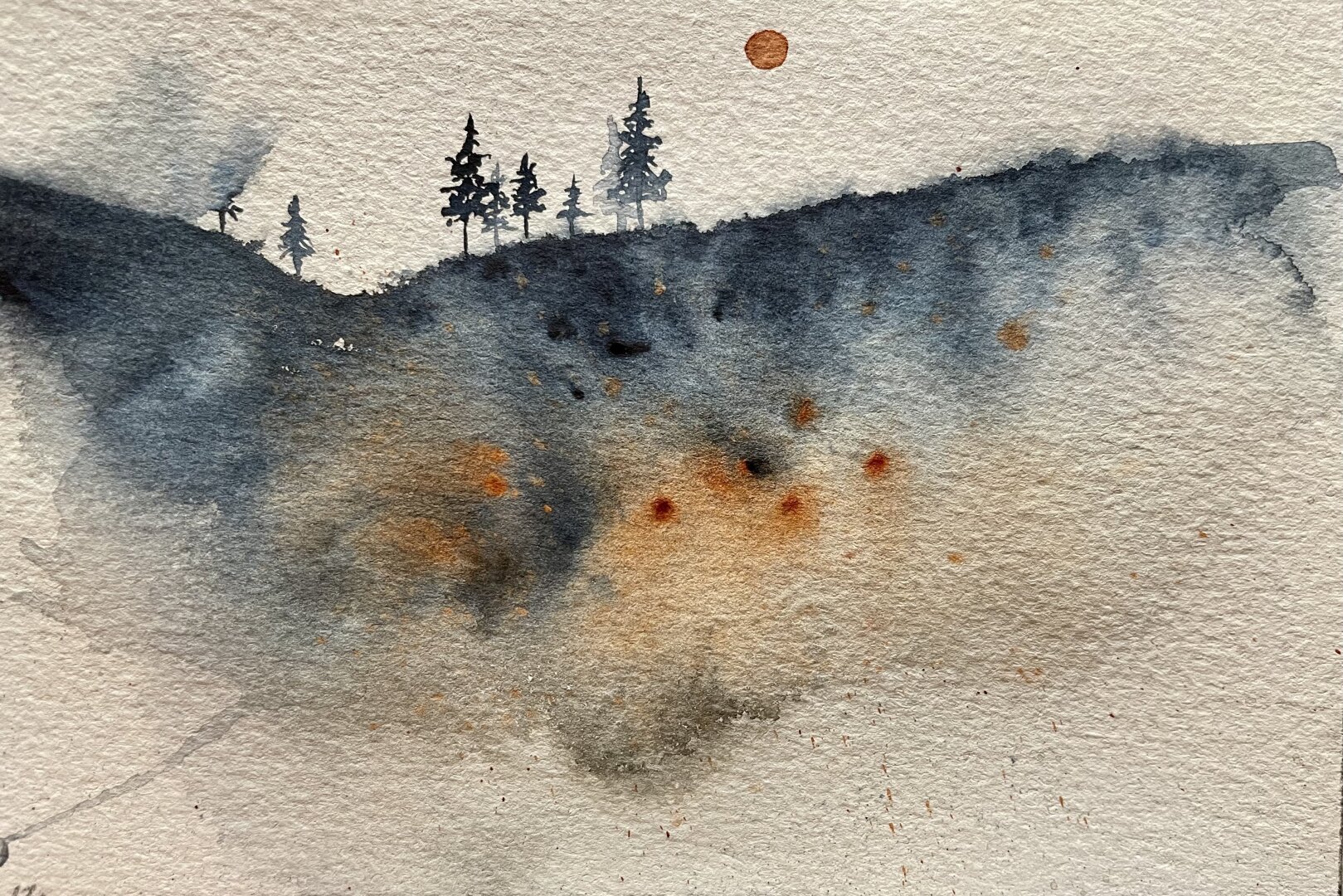 This watercolor painting depicts a misty hillside with dark blue and orange hues, featuring a small cluster of silhouetted pine trees at the top and a hazy sun in the sky.