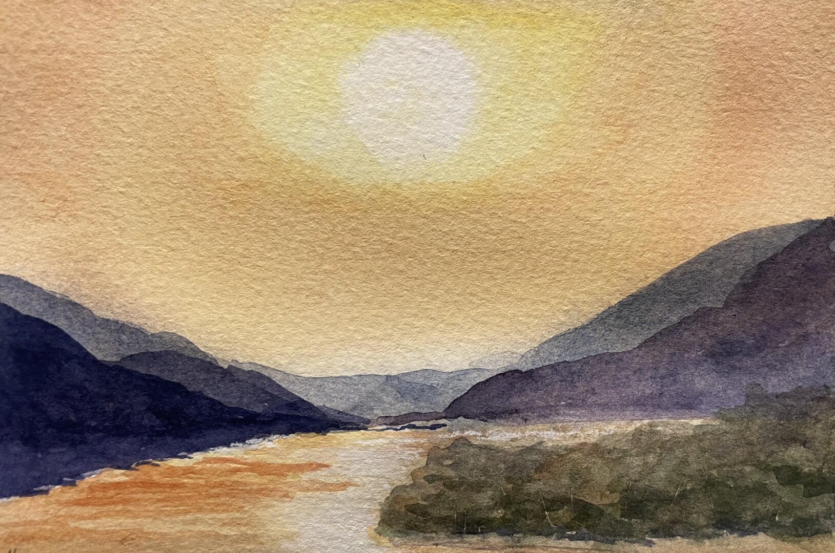 This watercolor painting depicts a serene landscape of a river flowing between mountains under a warm, glowing sun, with soft, blended tones of orange, yellow, and deep blues creating a tranquil atmosphere.