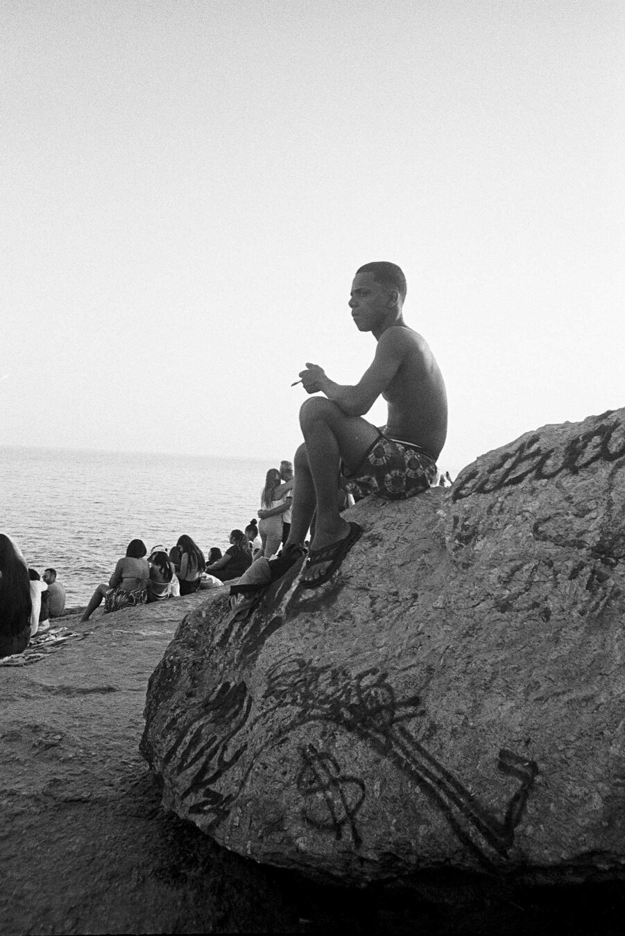 Pedra do Arpoador, teenager on rock smoking a cigarette