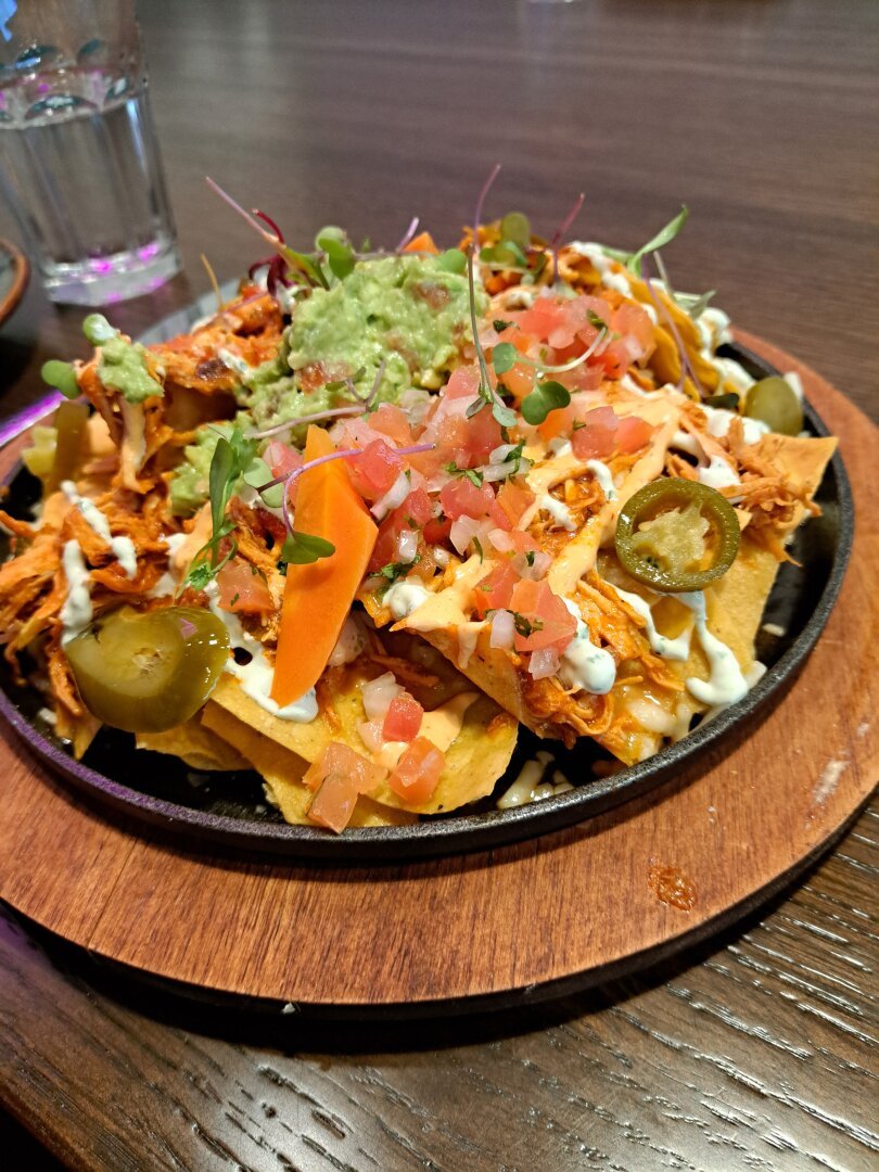 Plate of fully loaded nachos at Nom Noms. The distribution of ingredients was amazingly consistent throughout eating!
