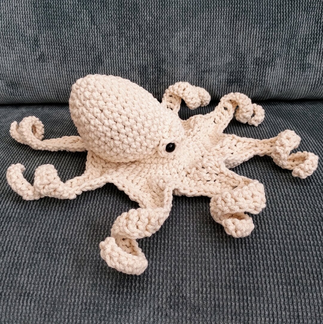 A quite naturalistic looking crochet octopus in off-white yarn.