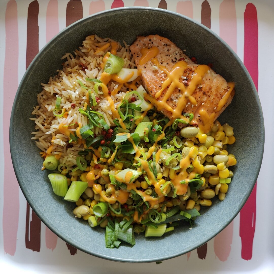 Mi-cuit de saumon, riz basmati à la citronnelle, maïs, petits pois, edamame, oignons jeunes et coriandre, avec une touche de mayo sriracha.