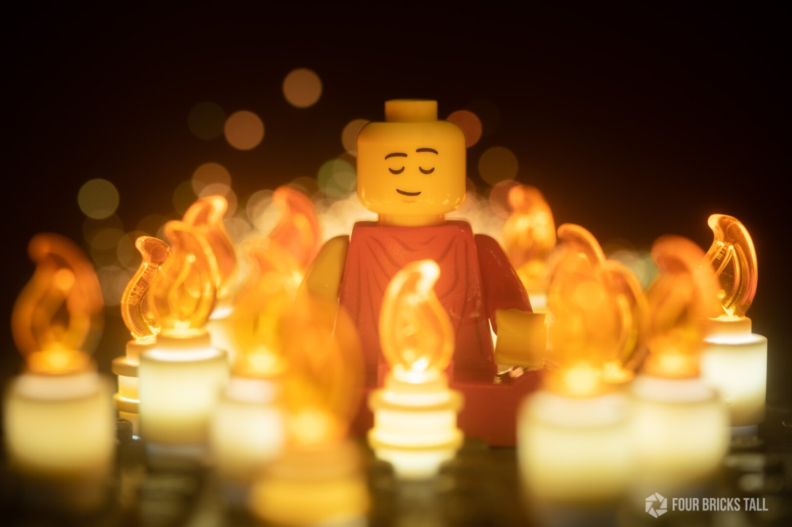LEGO monk sitting among candles