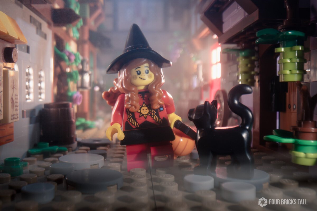 LEGO girl minifigure in witch's costume in a medieval alley