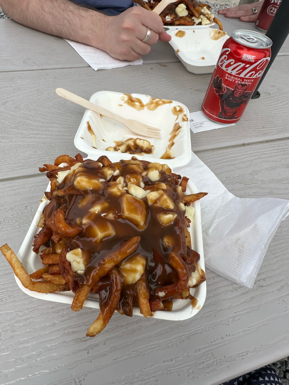 an overflowing takeout container of poutine