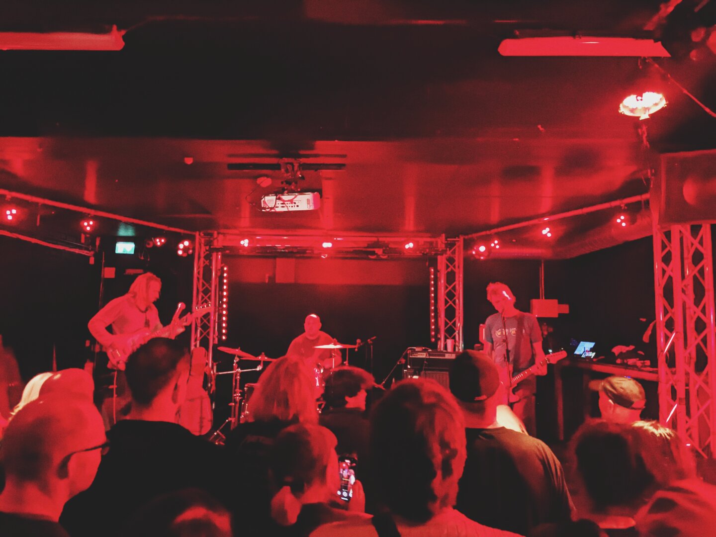 A band (Destructive Noise) and audience lit by red light