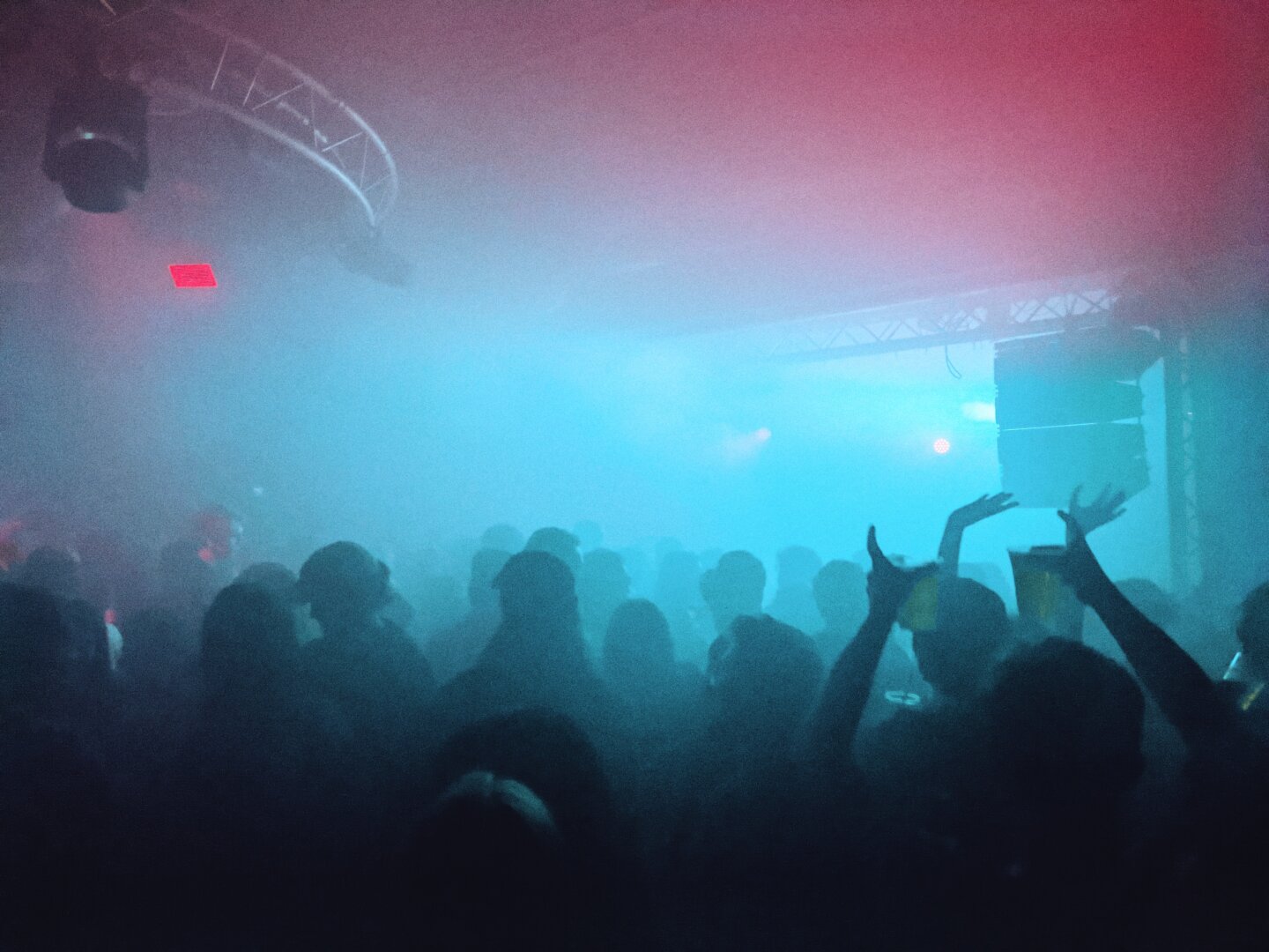 A crowd dancing lit by blue light