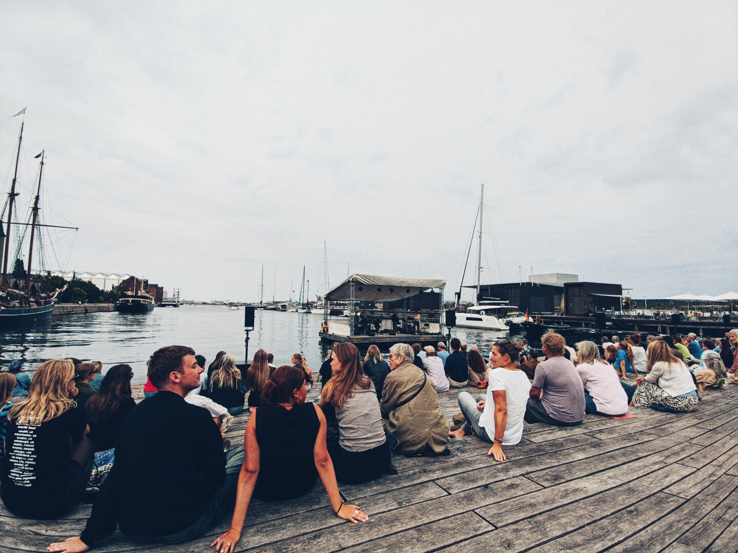 A crowd overlooking a floating stage in the water.