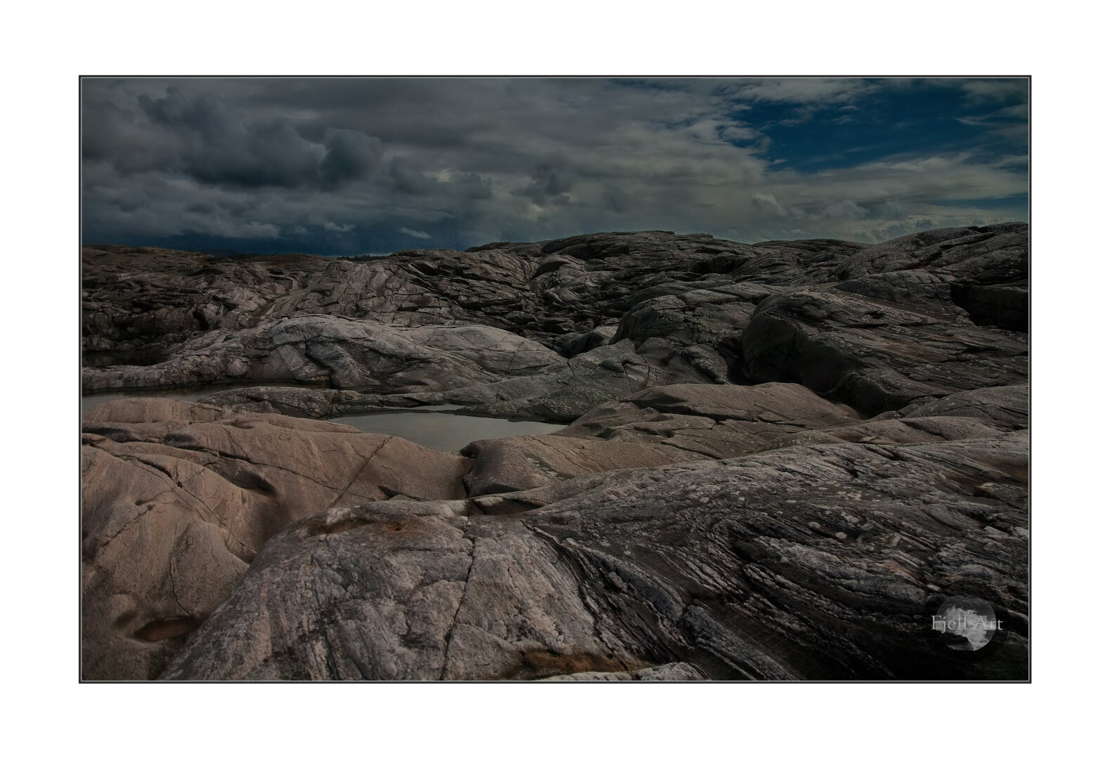 Rocks, rocks, rocks and the cloudy sky on the horizon.