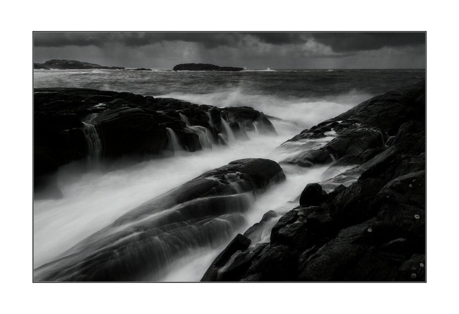 Black and white, long exposure waves on the rocks. Dark