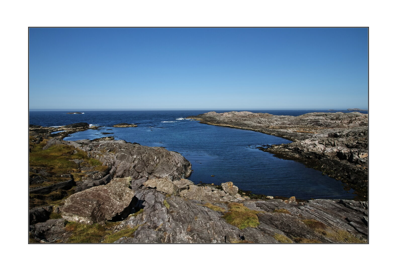 Ocean rocks under blue sky.