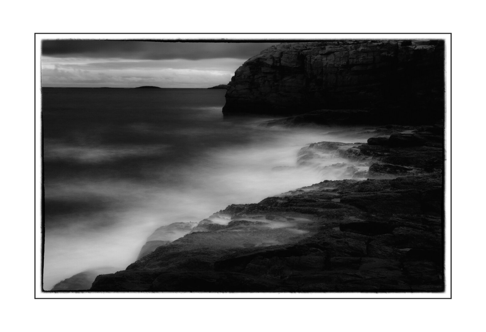 High waves on the rocks. Long exposure, Dark. Mood. Black and white.