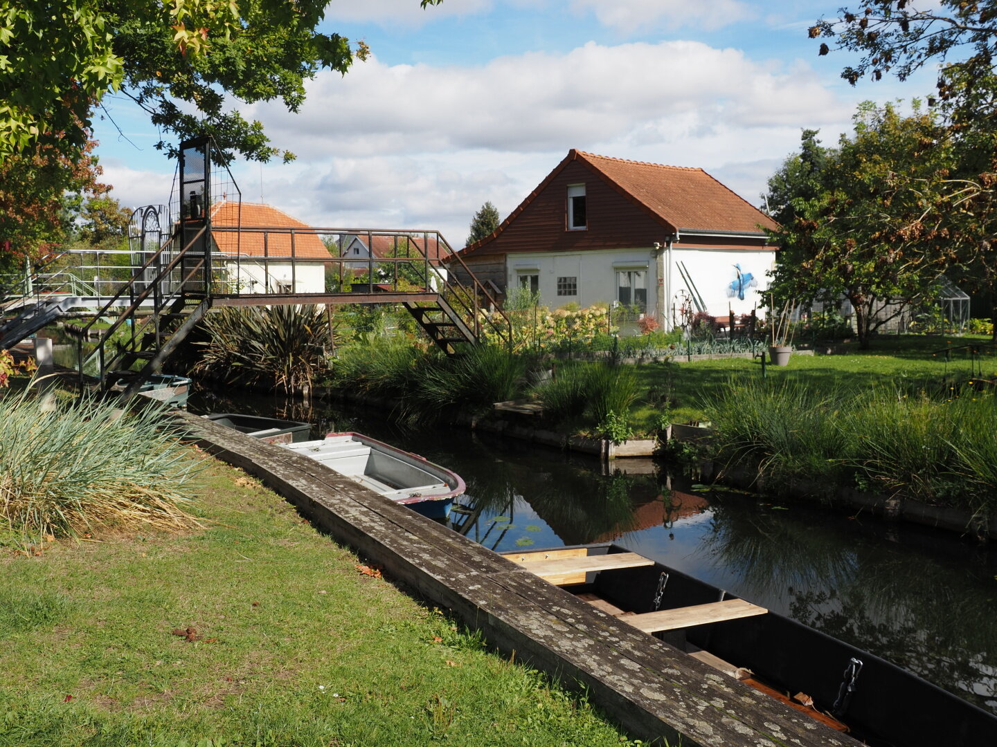 charming house nestled behind a tranquil canal with a few moored boats