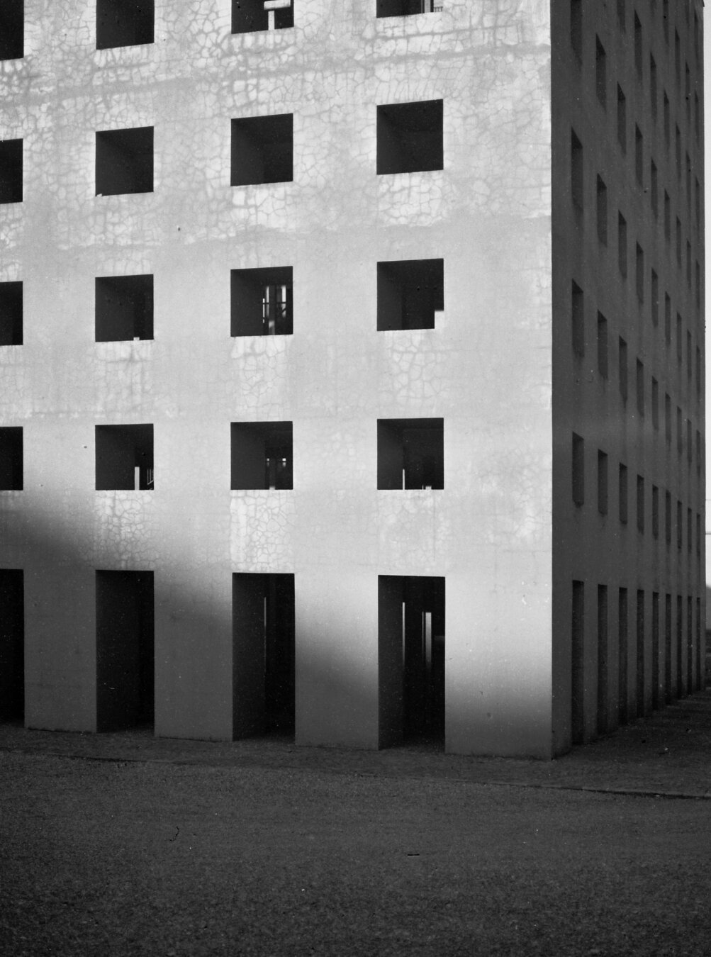 A cubic building with regular openings on its sides, black and white picture