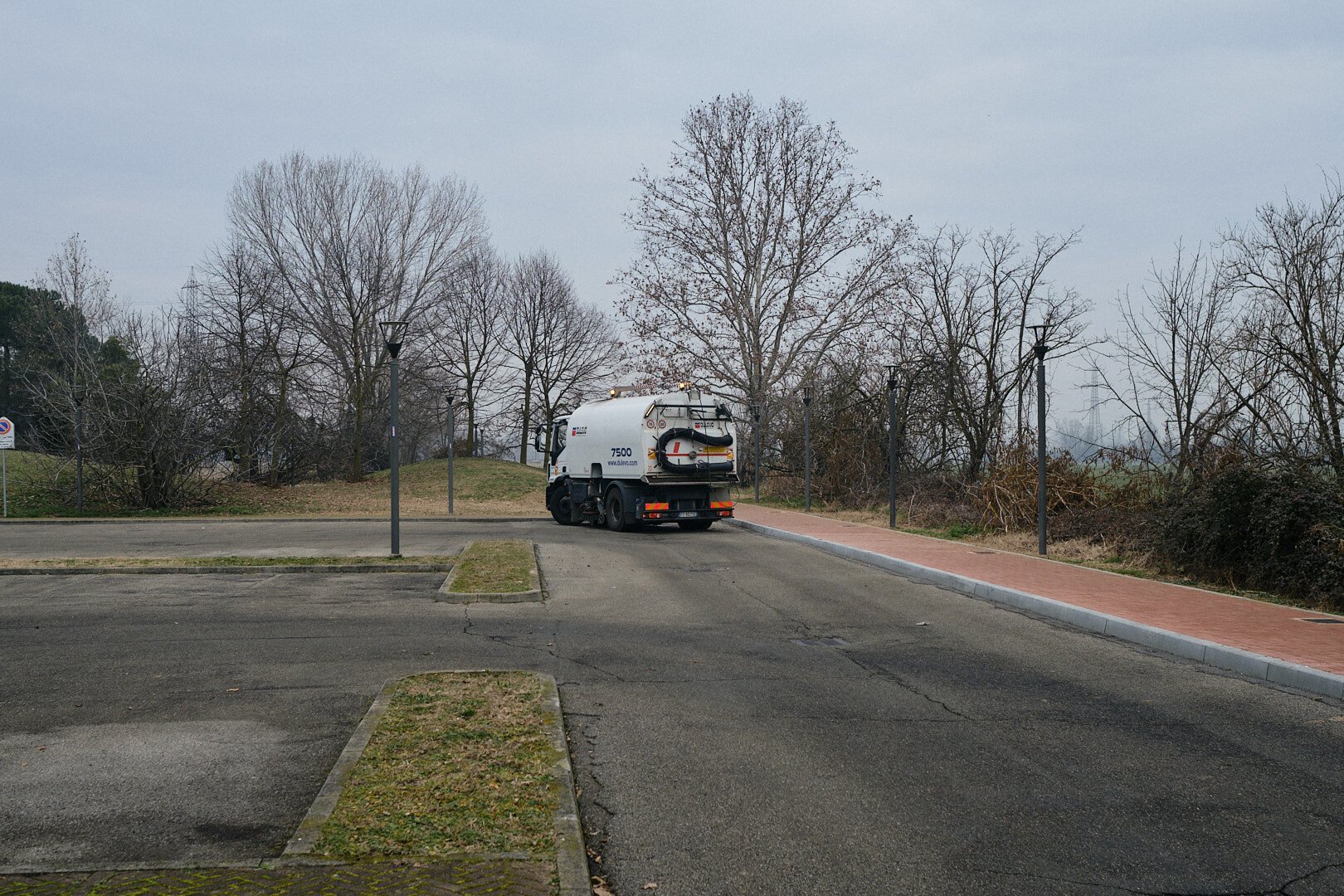 A truck idling in an empty parking lot in the countryside on a gloomy morning