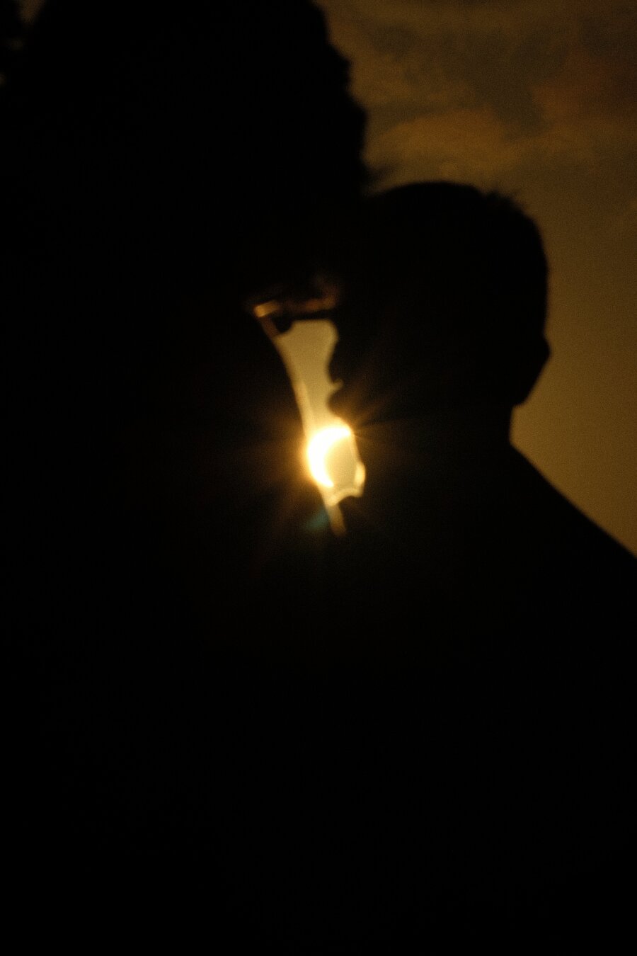 Partial eclipse visible in a gap between two people