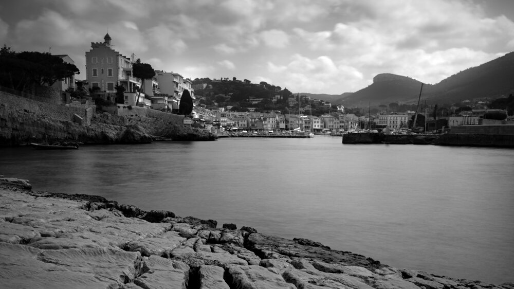 Pose longue en noir et blanc d'une vue du port de Cassis.