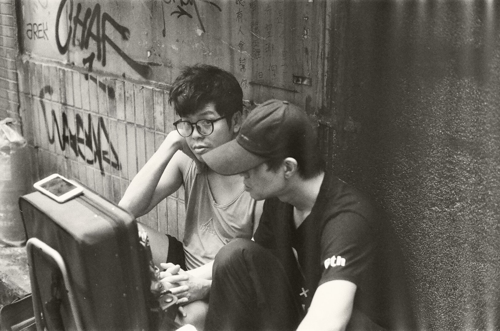 A couple holding hands sitting in an alleyway