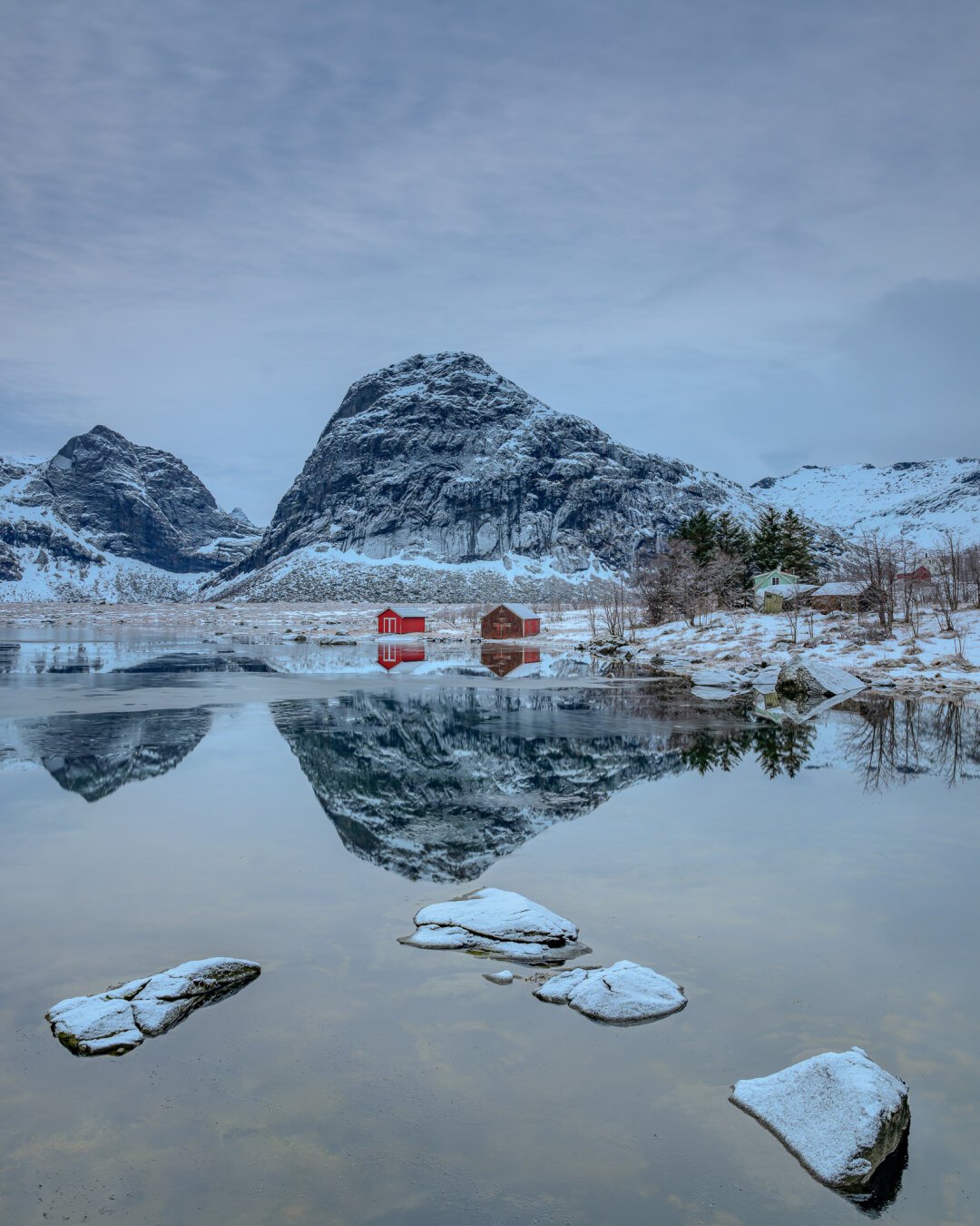 Zwei einsame Hütten am winterlichen Fjord