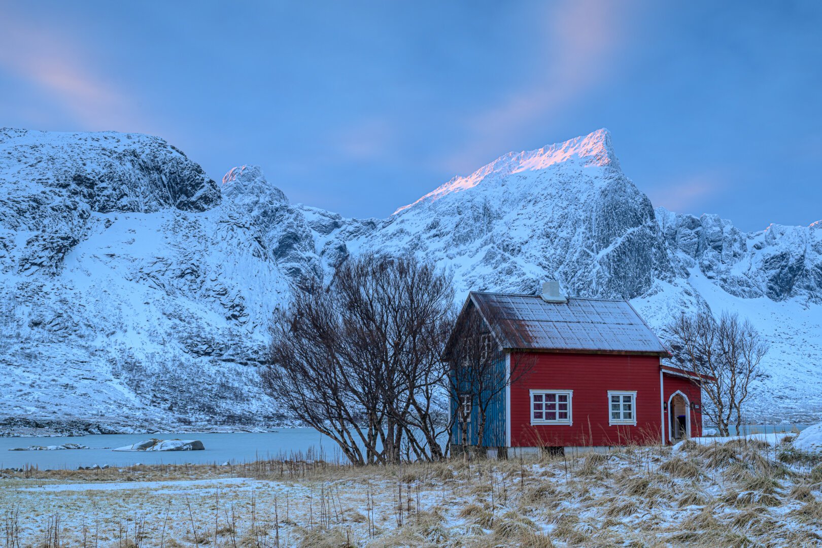 An old red hut in a winterly norwegian landscape