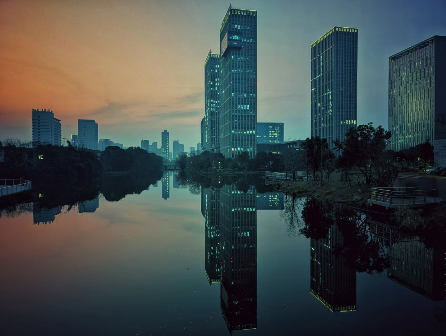 tall buildings in a sunset, reflected in water, with the blue colour channel pushed up