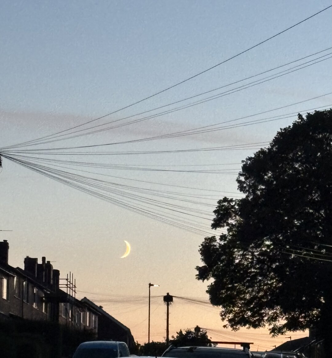 A piece of moon in a sunset sky