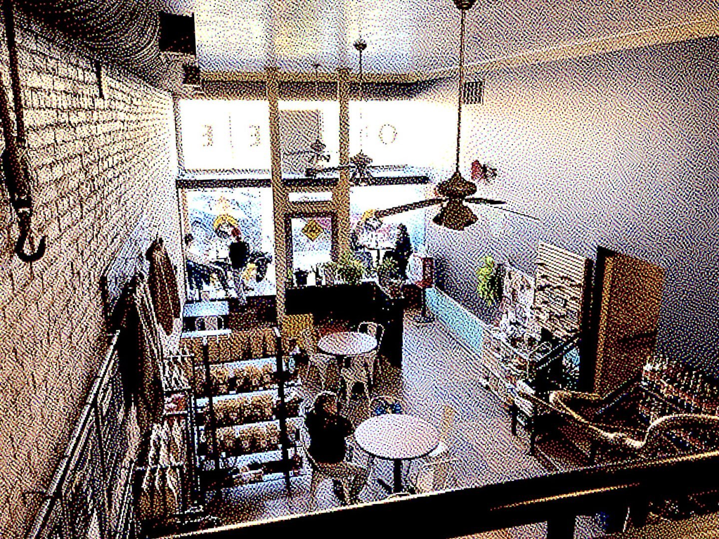 A pixelated photo of the inside of a coffee shop from a loft above the kitchen area.