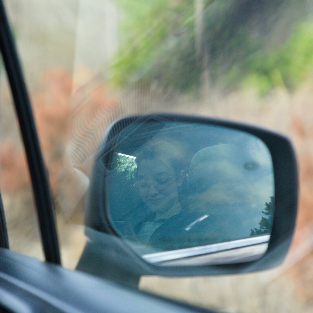 A person chalking their hands while climbing a rock face