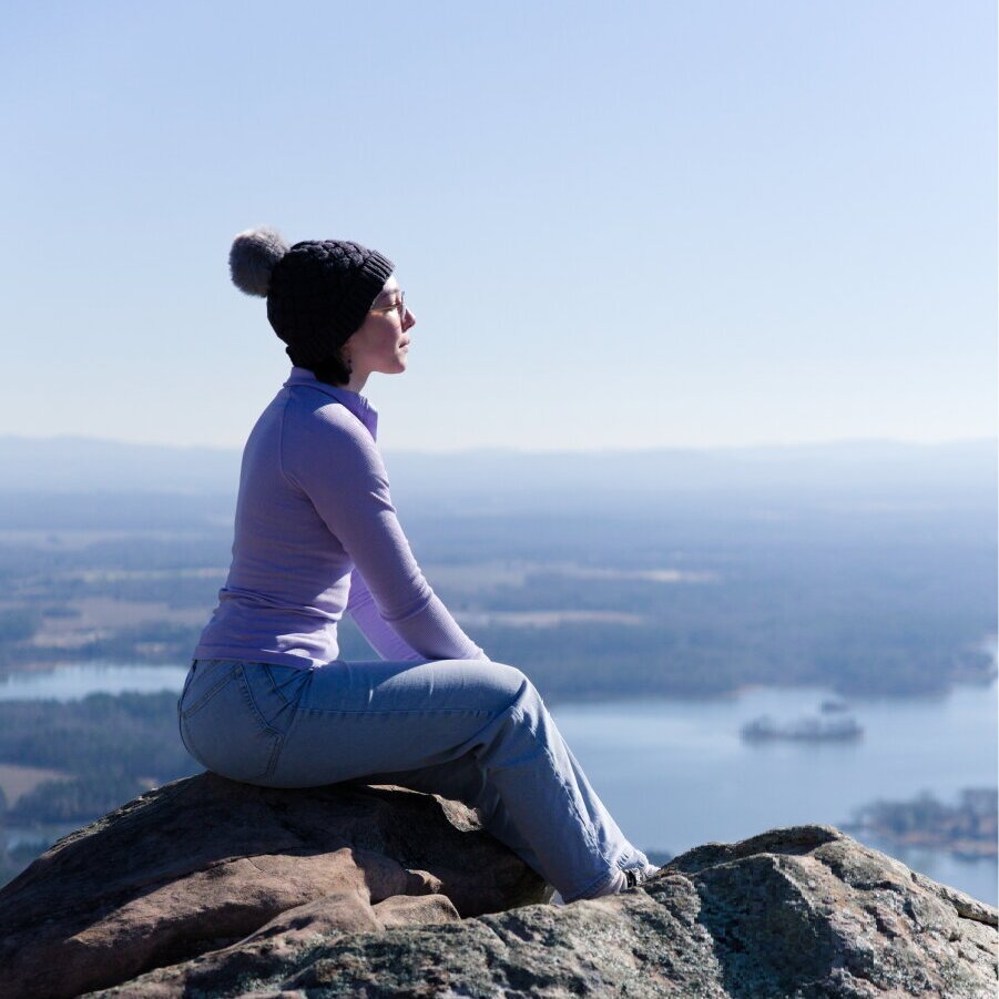 A person sitting, watching over a view from high up