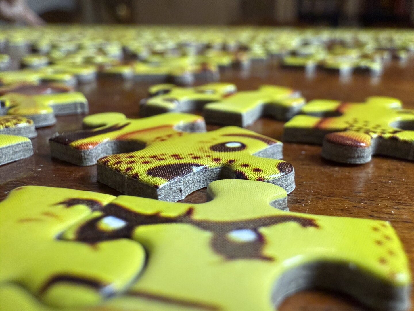 A macro shot of yellow puzzle pieces featuring Lego faces.
