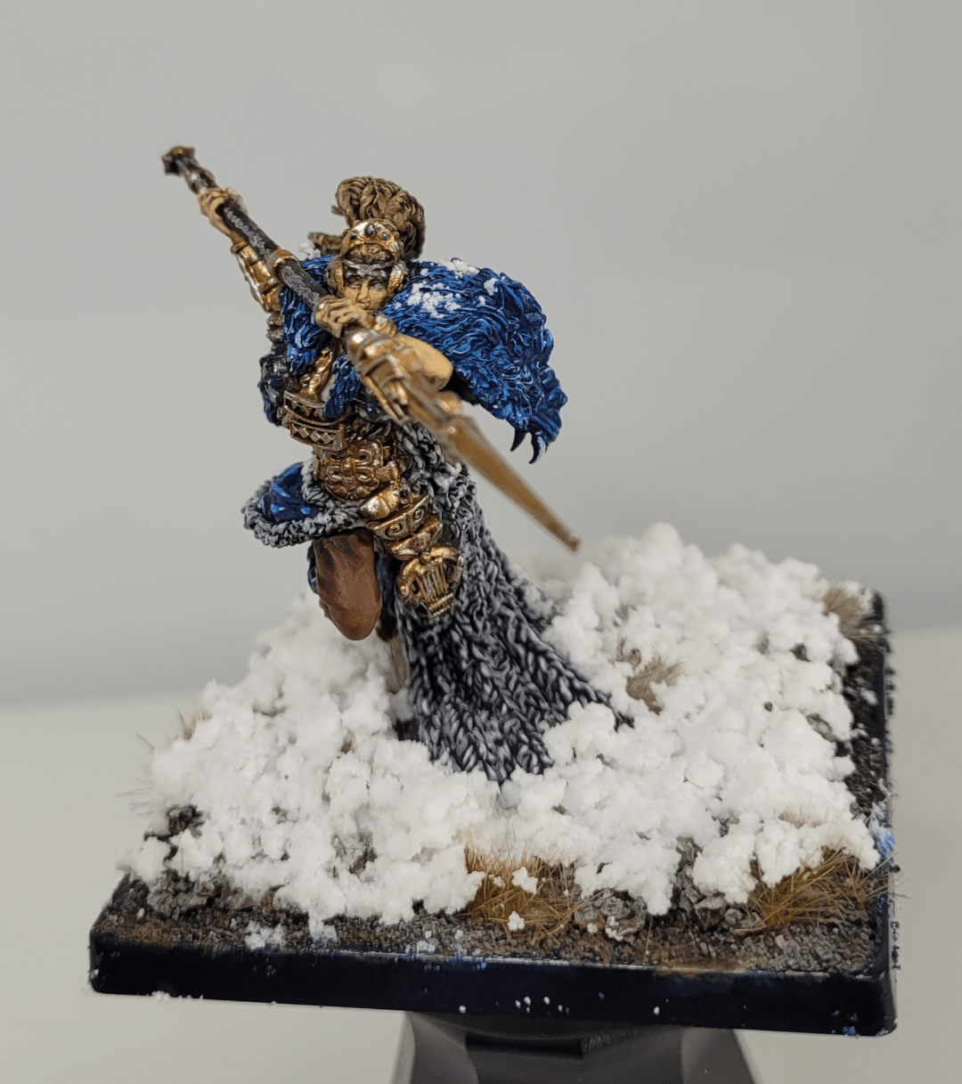 Artisan Jarl for Conquest Tlaok. Looking forward spear raised, painted in blue, grey and brown and standing on a snowy base.