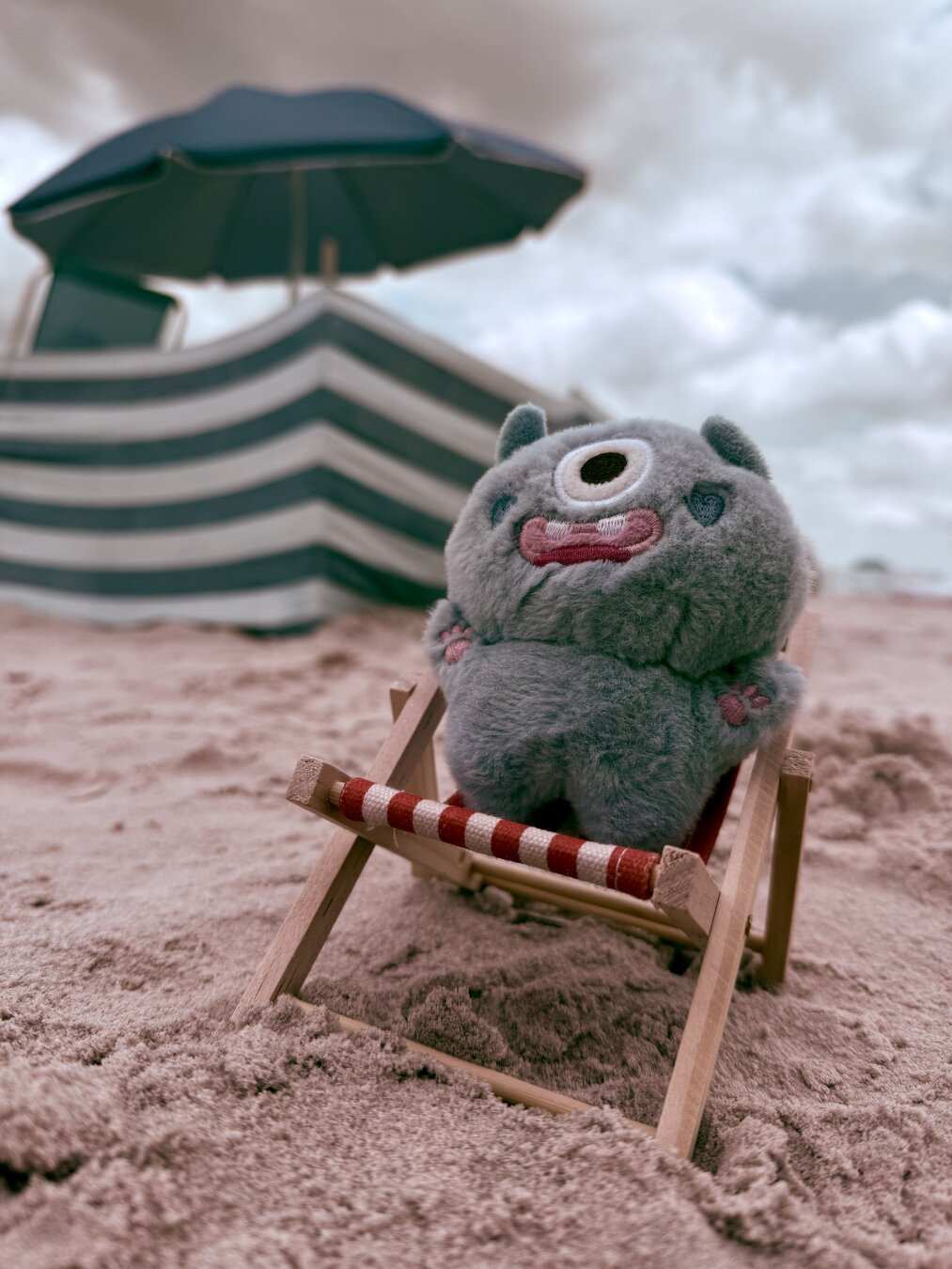 Masktka Cyklopsik na plaży w tle parawan i parasol