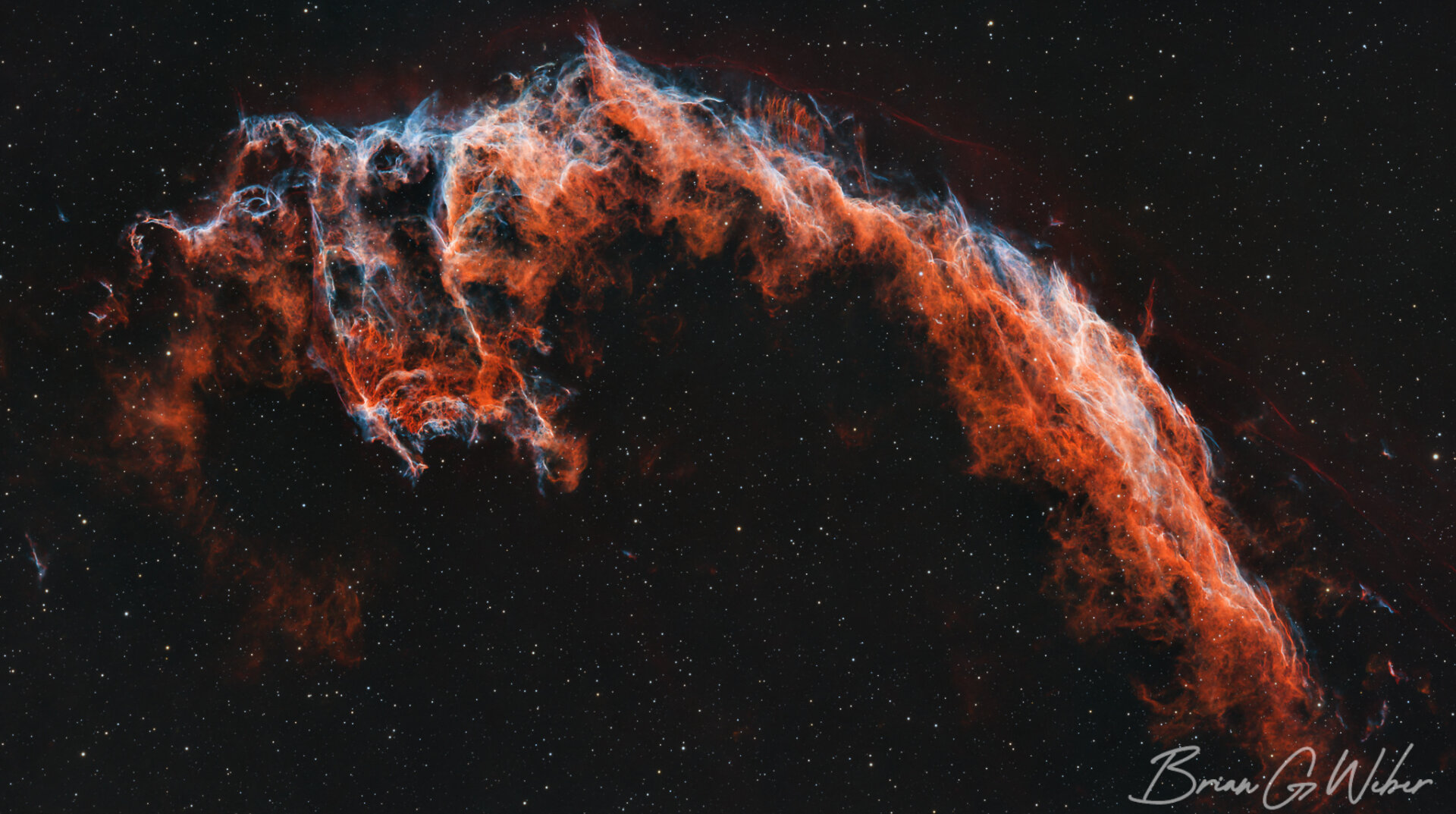 A tight view of the Eastern Veil Nebula in the constellation Cygnus. This supernova remnant has colorful, textured bands of hot gas showing brightly in SII, OIII, and H-alpha emission bands.