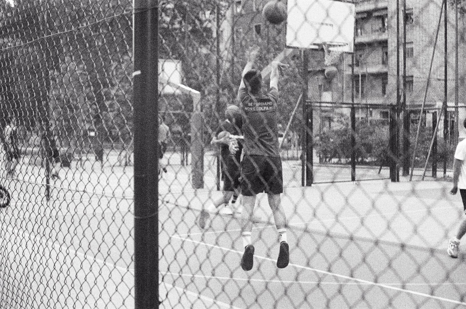 A boy shooting a basket ball in a playground