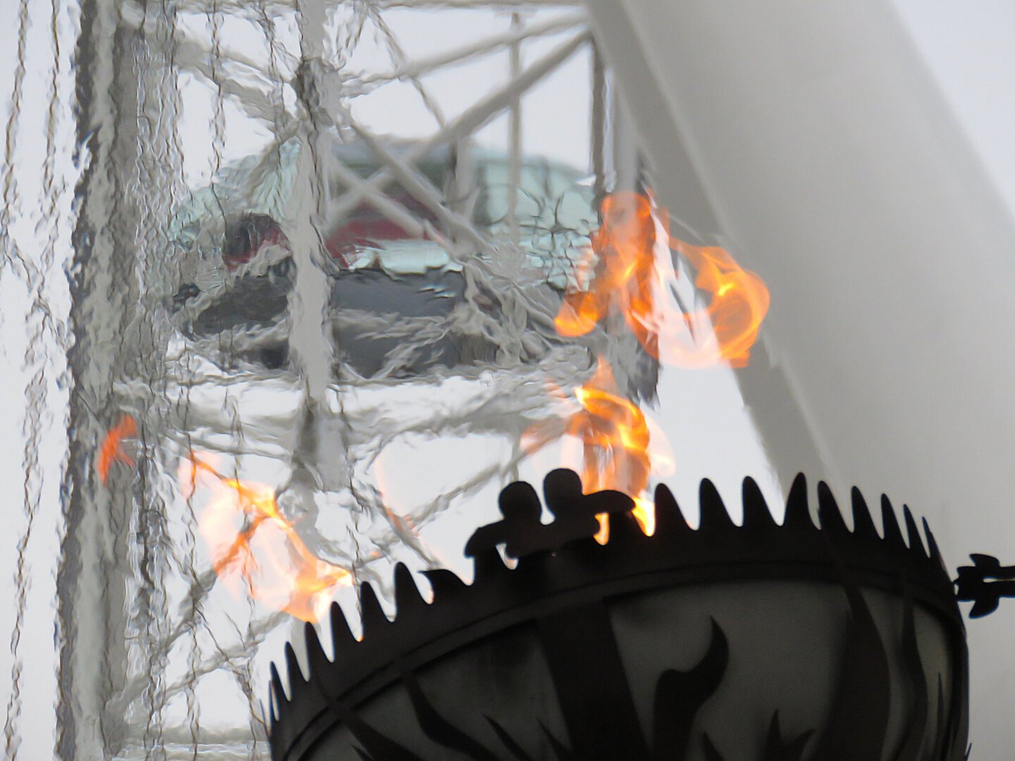 Distorted view of the London Eye through the flame of a torch outside the London Dungeon.