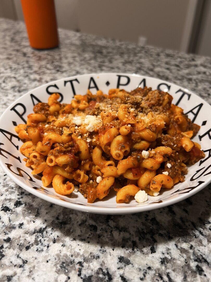 A bowl of cavatappi pasta with a meat sauce