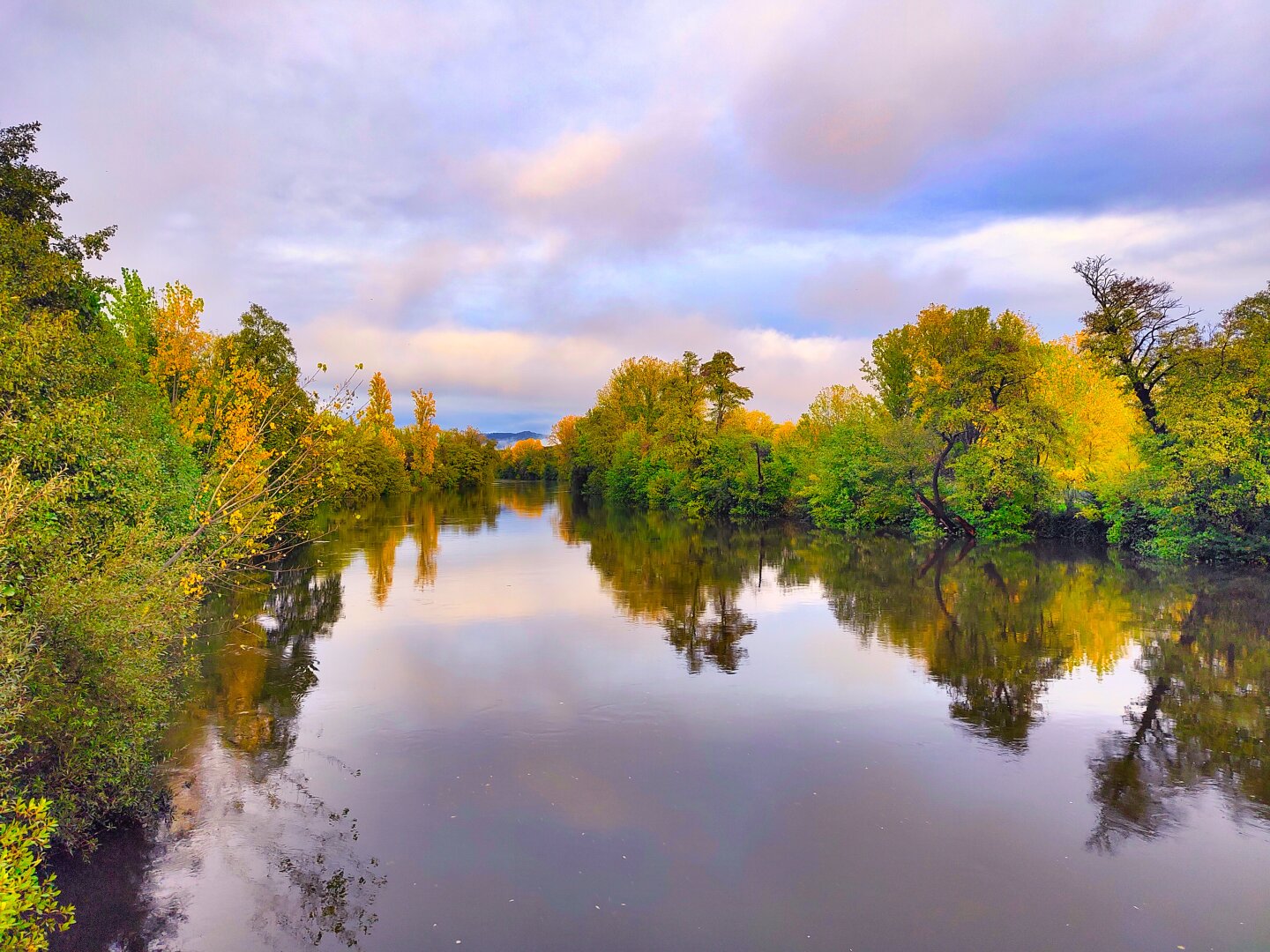 Río Jerte, Plasencia, Extremadura, gran caudal, el río en calma, los bordes del río lleno de vegetación, cielo parcialmente nuboso, foto desde un puente que cruza el río.