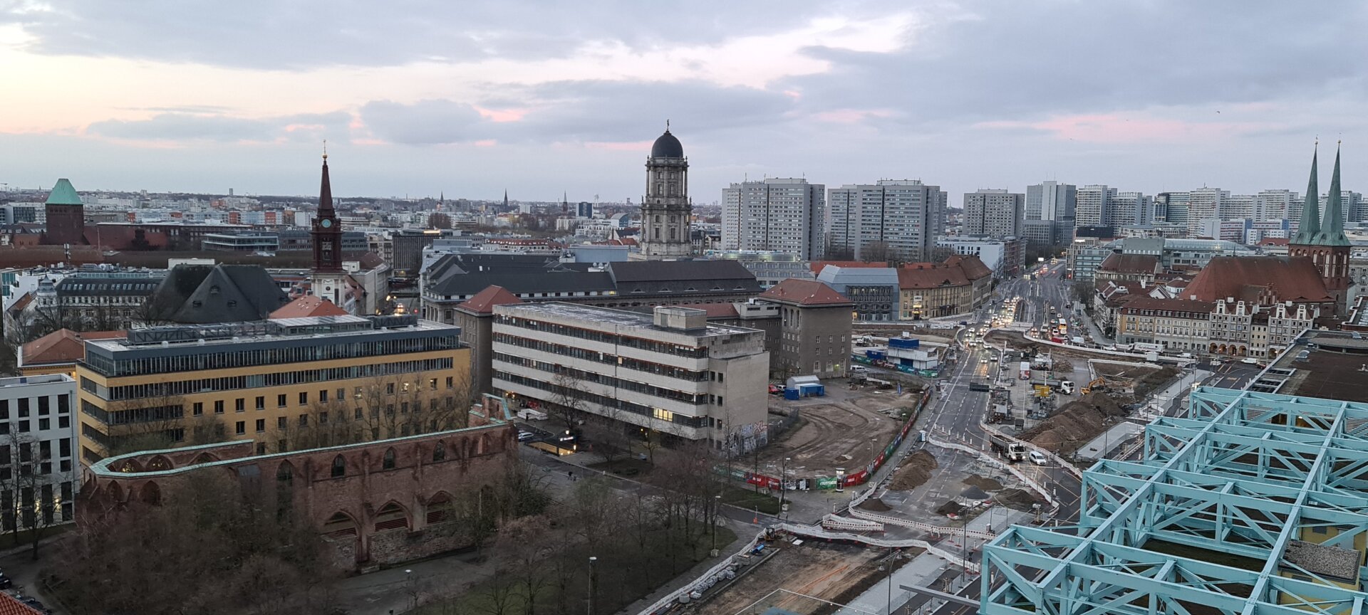 Stadtlandschaft Berlin von einem erhöhten Standort ,it Klosterruine, großer Baustelle auf der Grunerstraße, Turm des Alten Stadthauses, Wohnhochhäusern und St. Nikolai uunter einem grauen Himmel