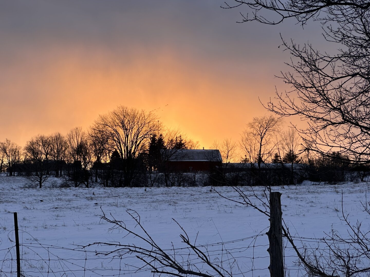 I’ve parked on the side of the road, and across the farmers field, up on a slight hill there is the silhouette of a barn. The sun has almost completely set behind the barn, and the sky is a very bright orange and yellow as it fades into the sky. It looks like a raging fire is behind the barn.