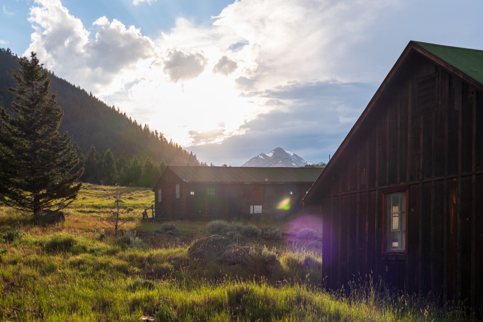 The sun sets behind a mountain and cabins. [Fuji X-T5 / Sigma 17-40 1.8]