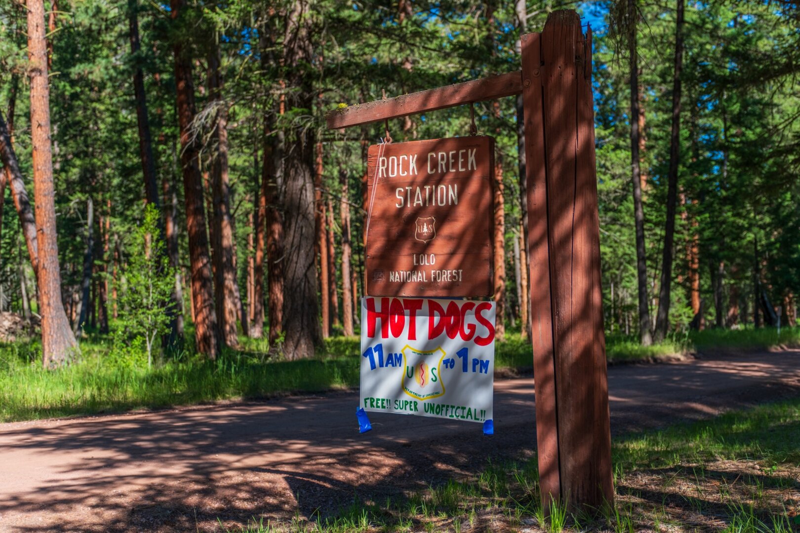 The sign for Rock Creek Station has been amended by a sign offering free hot dogs from the "US Hotdog Service", part of the "Department of Lunchings". [Fuji X-T5 / Sigma 17-40 1.8]