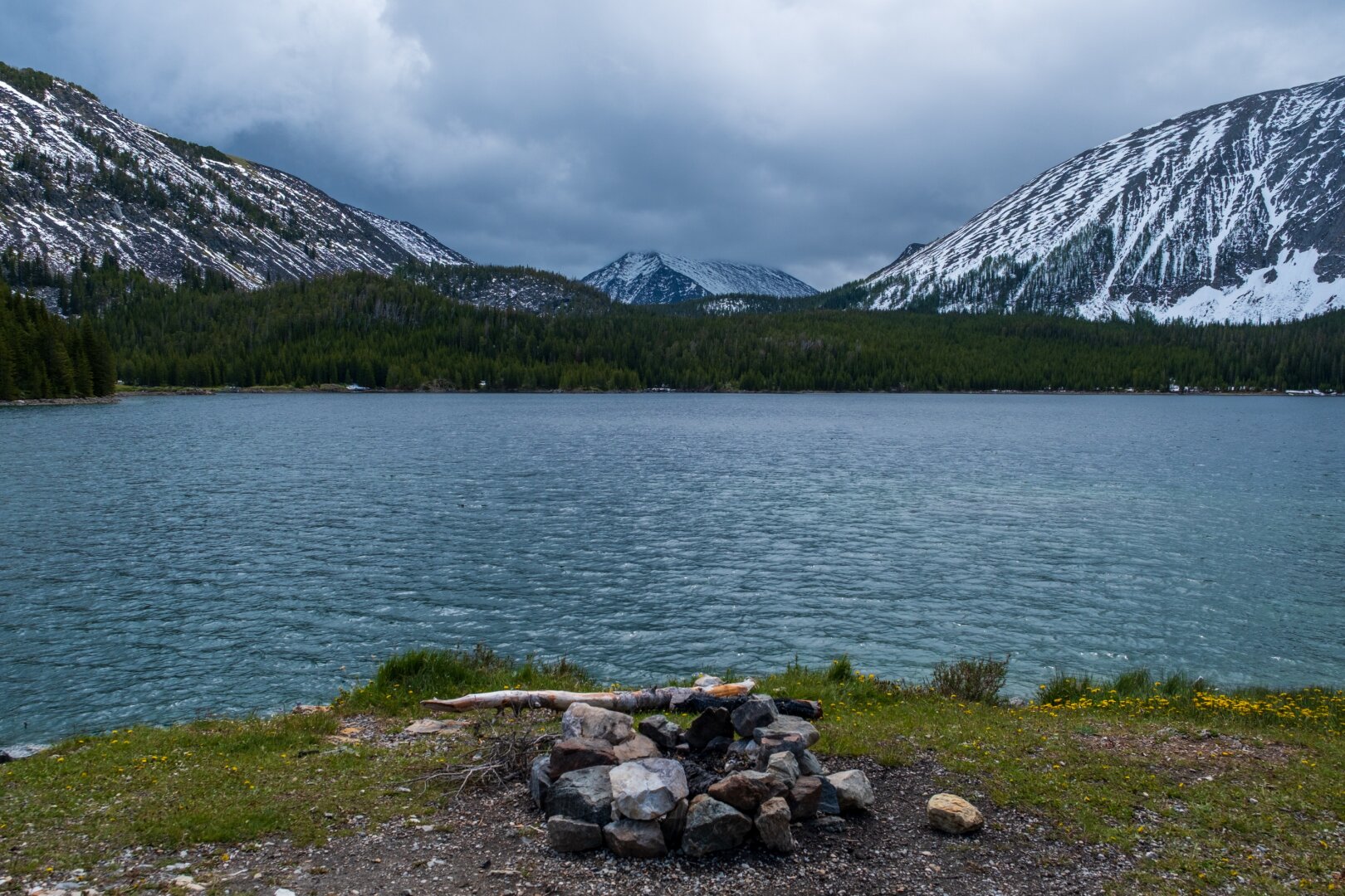A fire ring sits in front of a lake, with mountains behind. [Fuji X-T5 / Sigma 17-40 1.8]