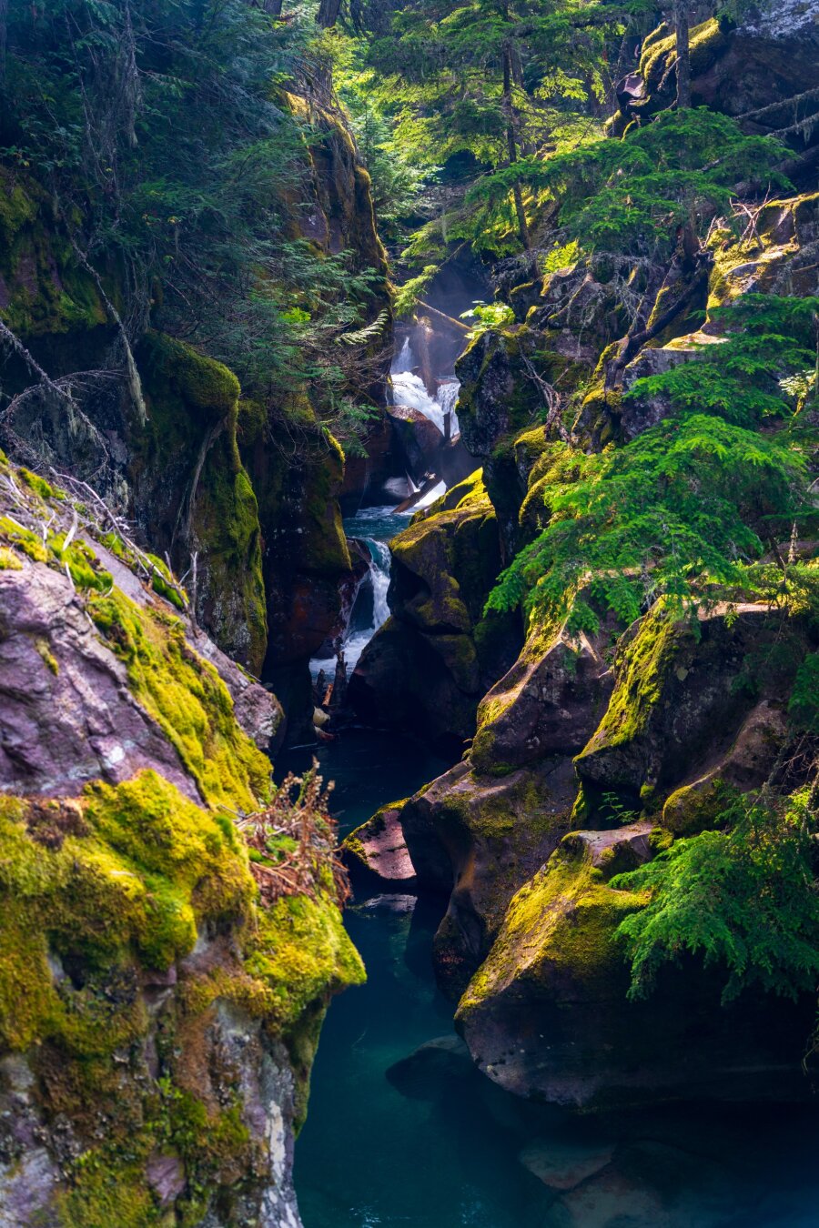 A very blue river winds through curvy, mossy rocks. [Sony A7R V / Tamron 25-200]