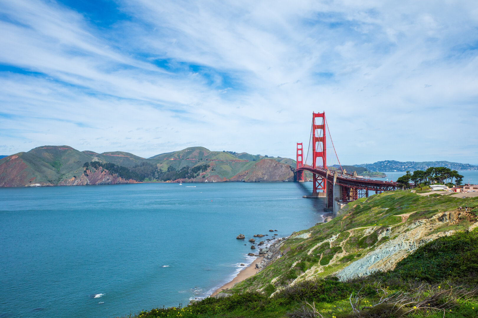 An orange bridge spans a gap between two land masses. [Ricoh GR III]