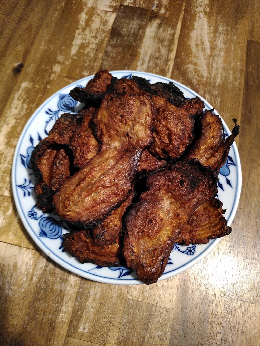 A plate on a table, with a heap of bacon-like crisp slivers on top.