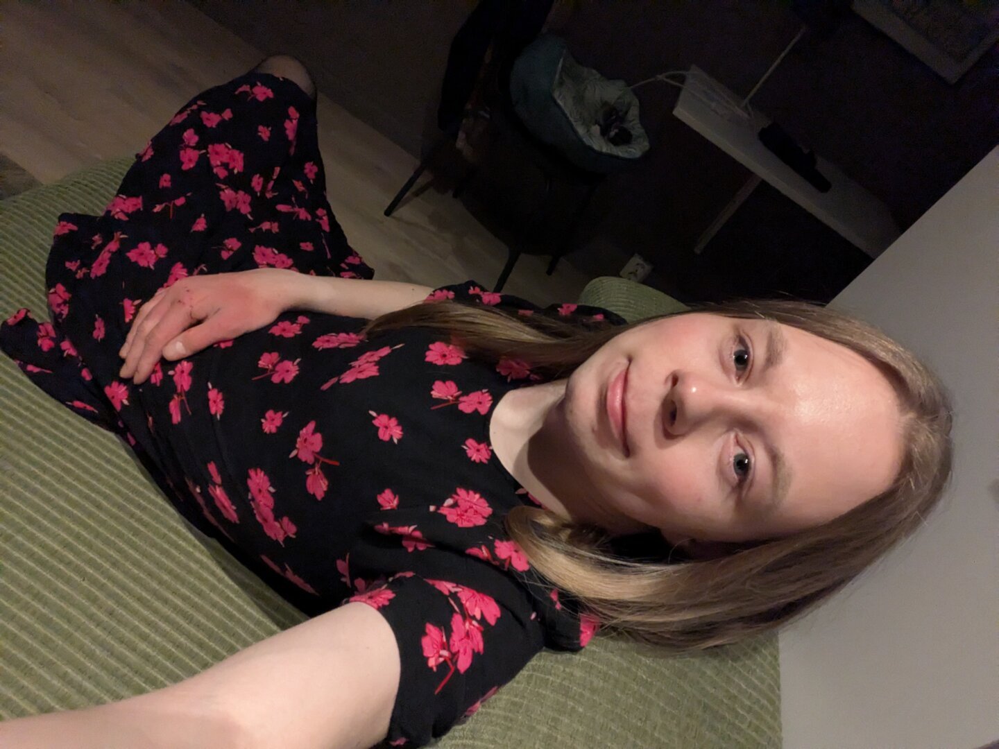 A woman lies prone on a couch in her apartment, posing for the camera.

In the background, a table can be seen.