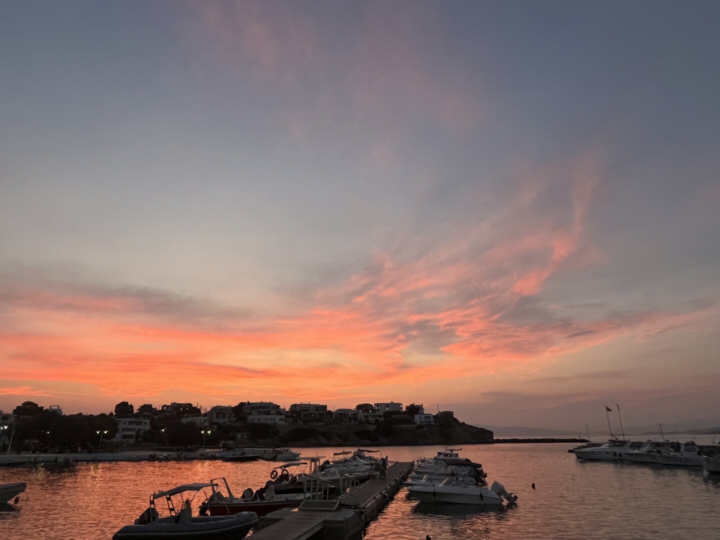 Sunset in a Greek port. Typical orange and gold hour colors .
