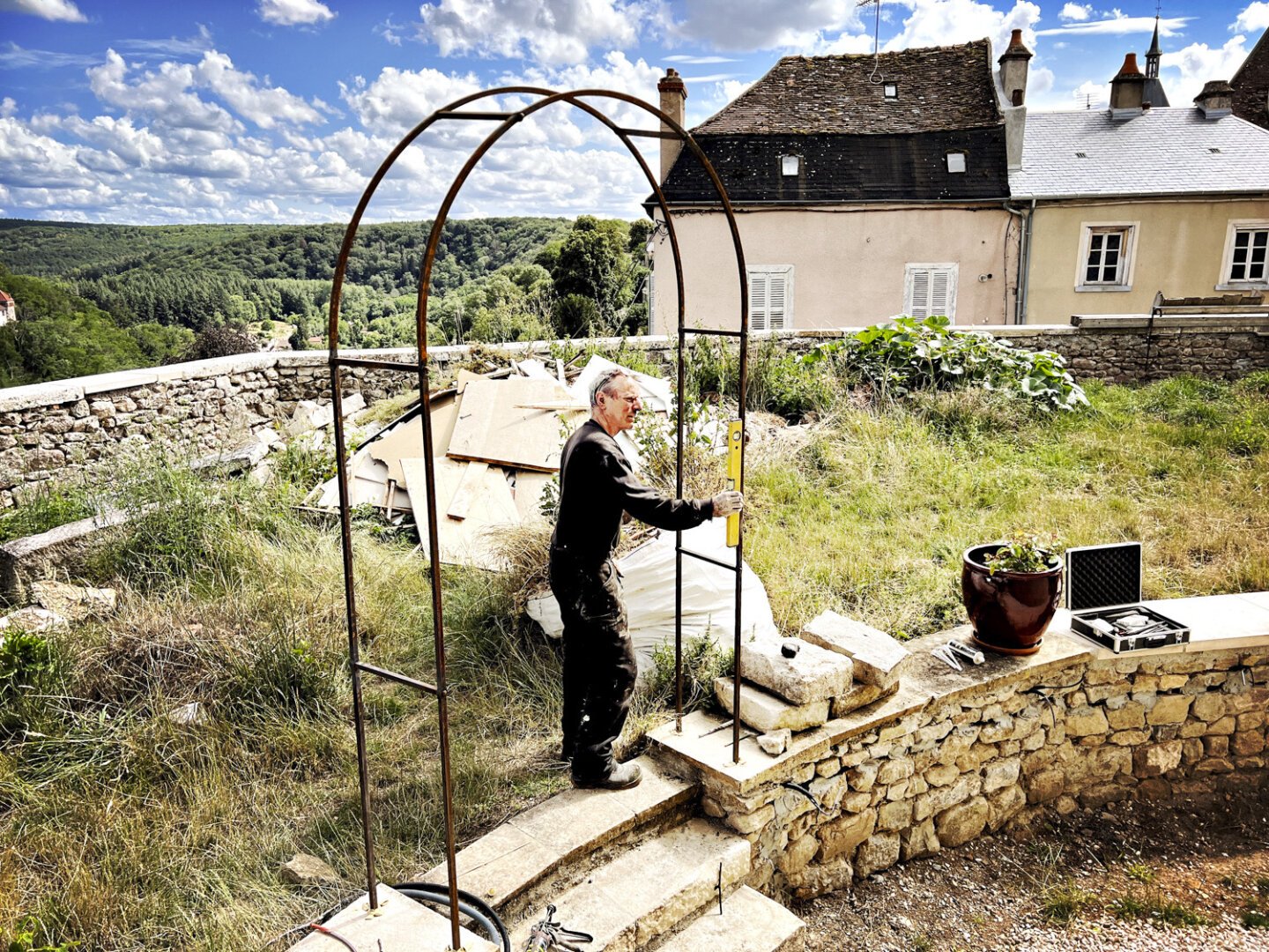 Jean vérifie les verticales et horizontales de la structure avec son niveau à bulle