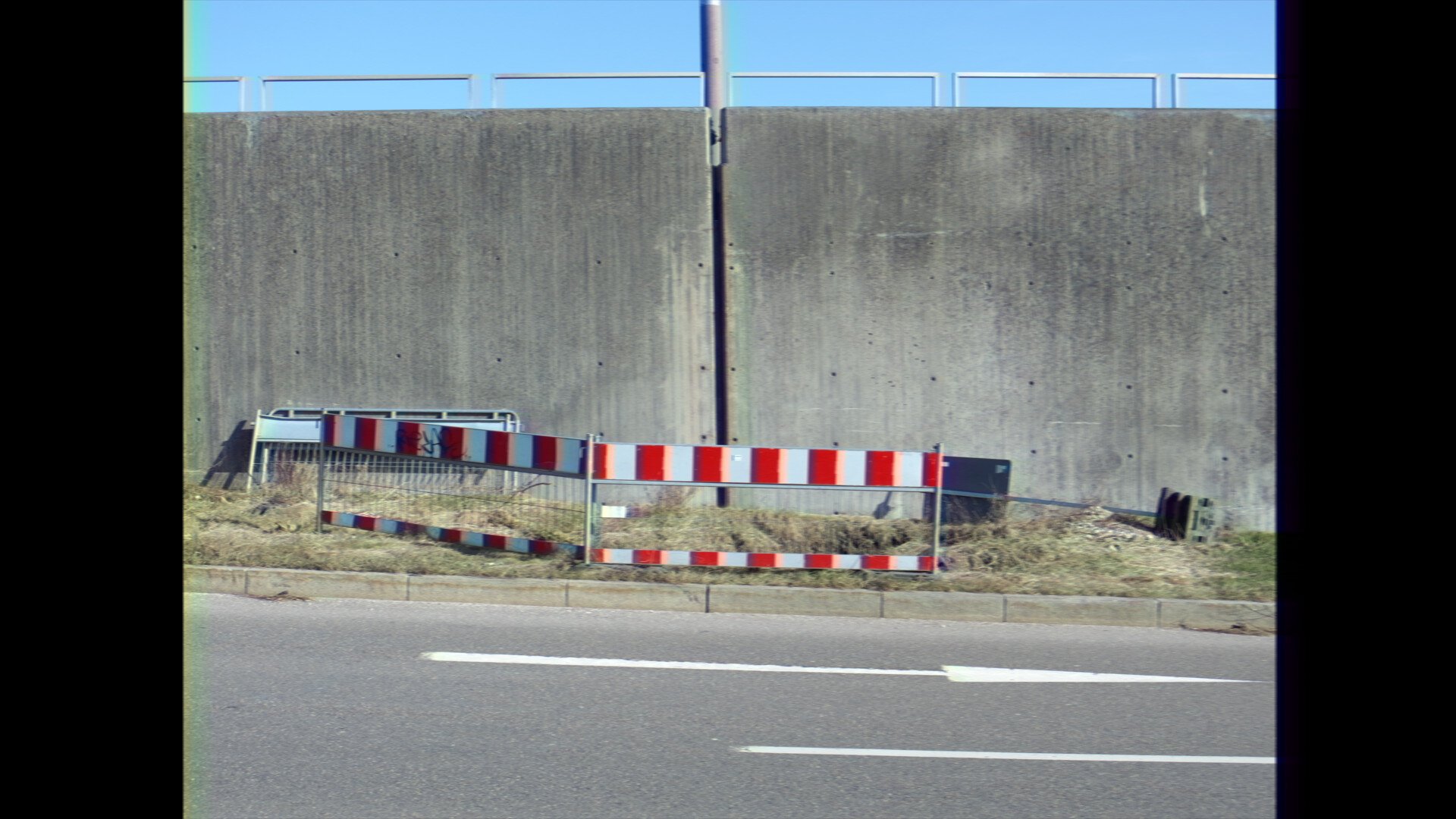 Photo of some construction signs in front of a concrete wall (light VHS filter)